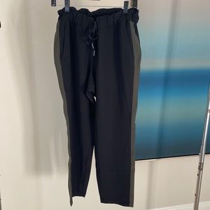 Lululemon black pant with an olive green stripe down the side, drawstring waist.
